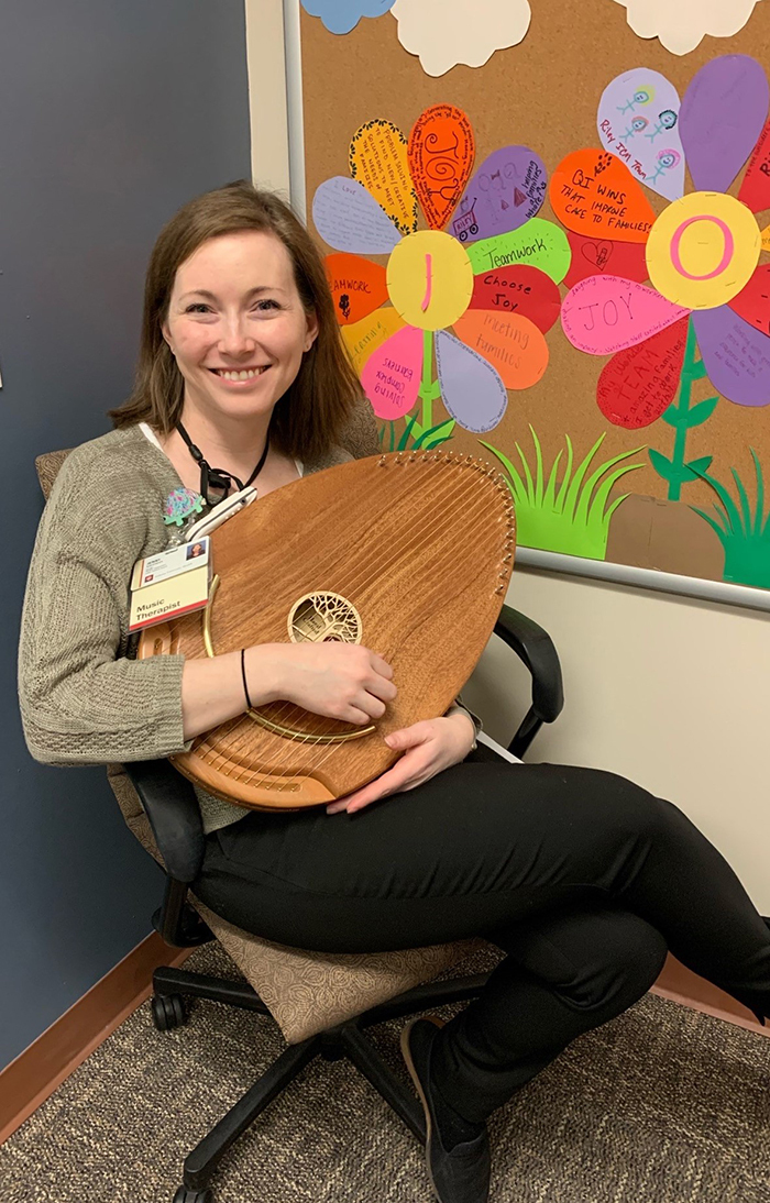 Jenny smiles with a harp