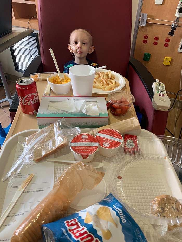 Miles sits with his hospital food