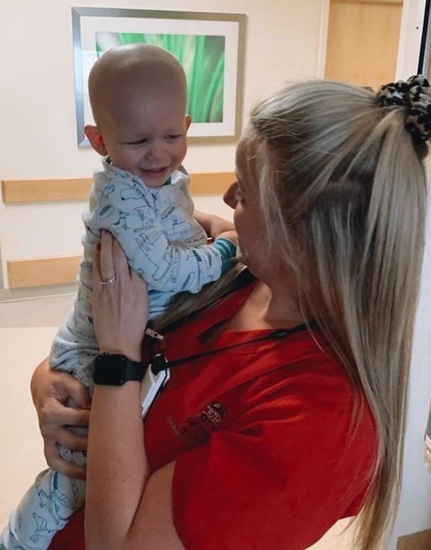 Heinzelman holds a patient as they exchange a laugh