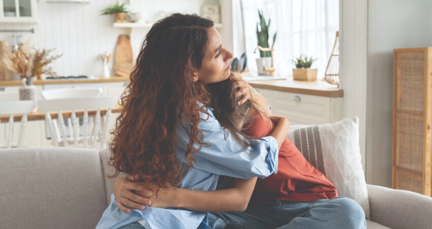 parent comforting child on couch