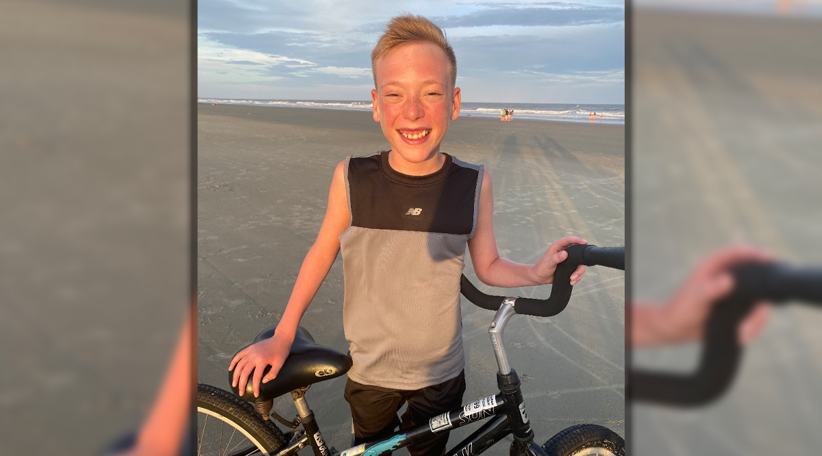 Lane Veach with his bike on the beach