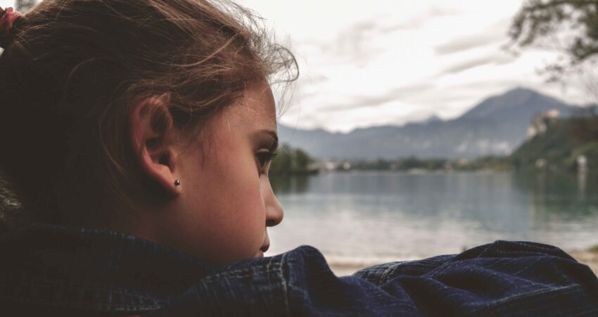 young girl looks sad outside